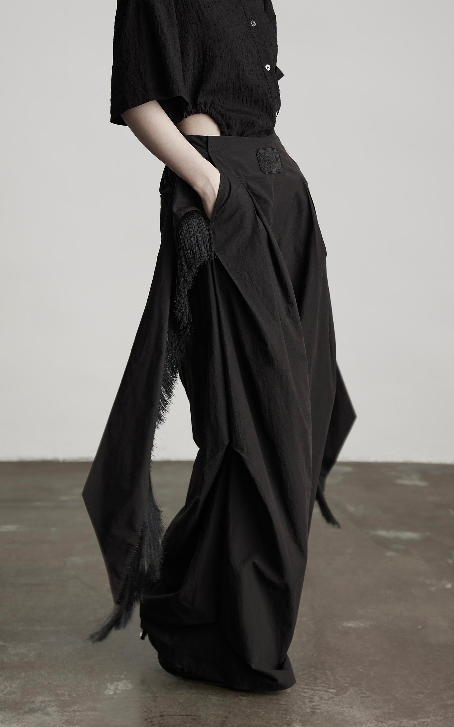 DOINDULGE Wide-Leg Draped Pants with Fringed Panels and Deconstructed Details