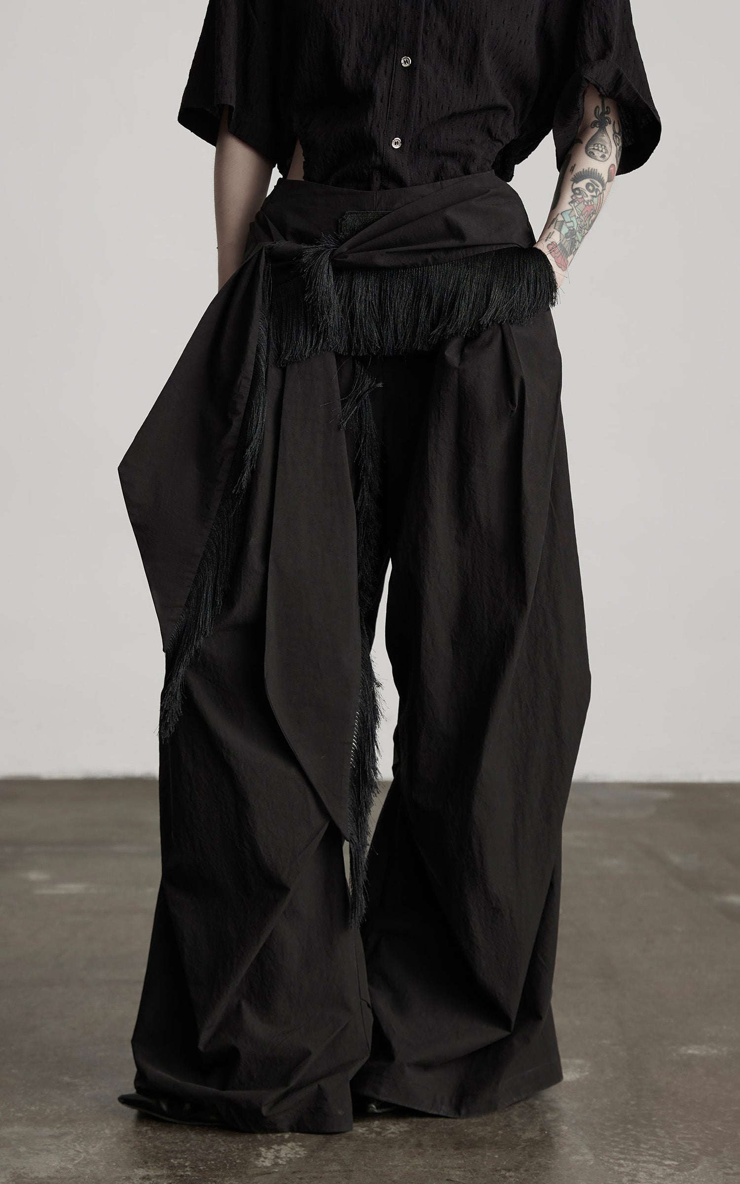 DOINDULGE Wide-Leg Draped Pants with Fringed Panels and Deconstructed Details