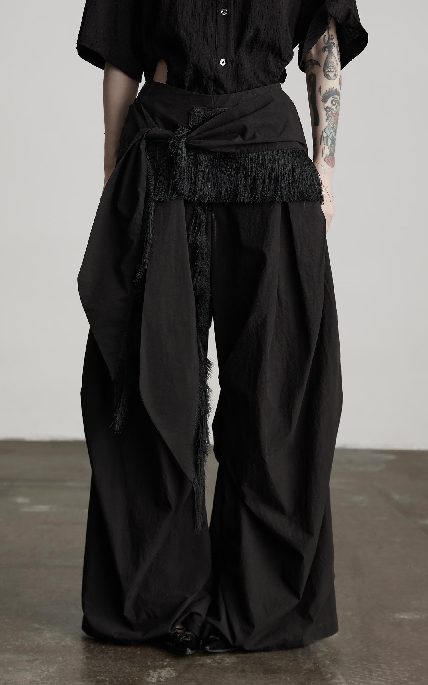 DOINDULGE Wide-Leg Draped Pants with Fringed Panels and Deconstructed Details