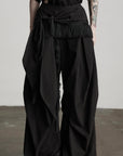 DOINDULGE Wide-Leg Draped Pants with Fringed Panels and Deconstructed Details