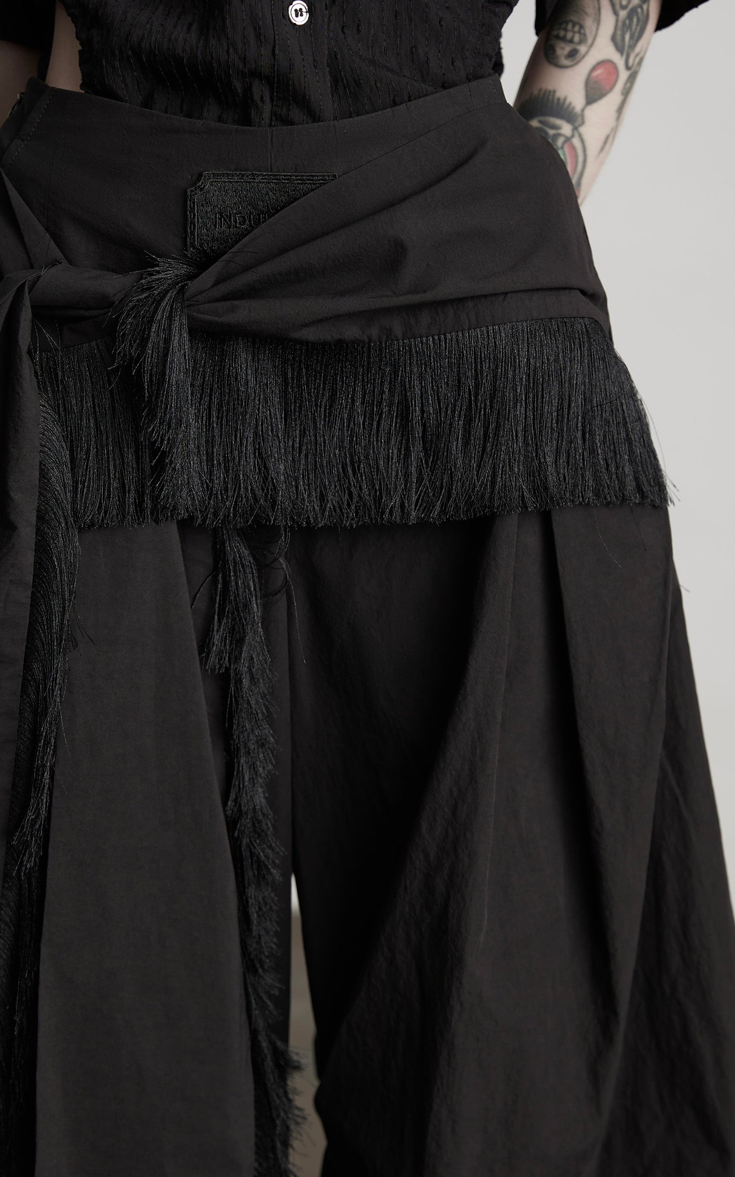 DOINDULGE Wide-Leg Draped Pants with Fringed Panels and Deconstructed Details