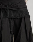 DOINDULGE Wide-Leg Draped Pants with Fringed Panels and Deconstructed Details
