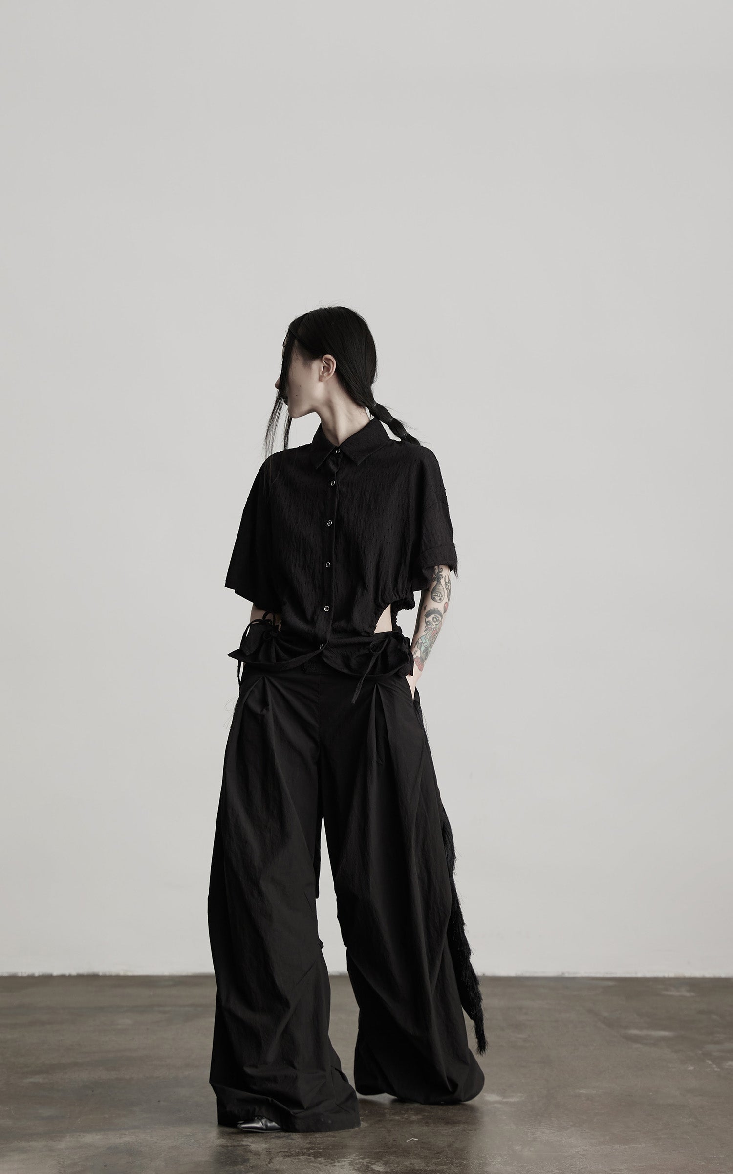 DOINDULGE Wide-Leg Draped Pants with Fringed Panels and Deconstructed Details